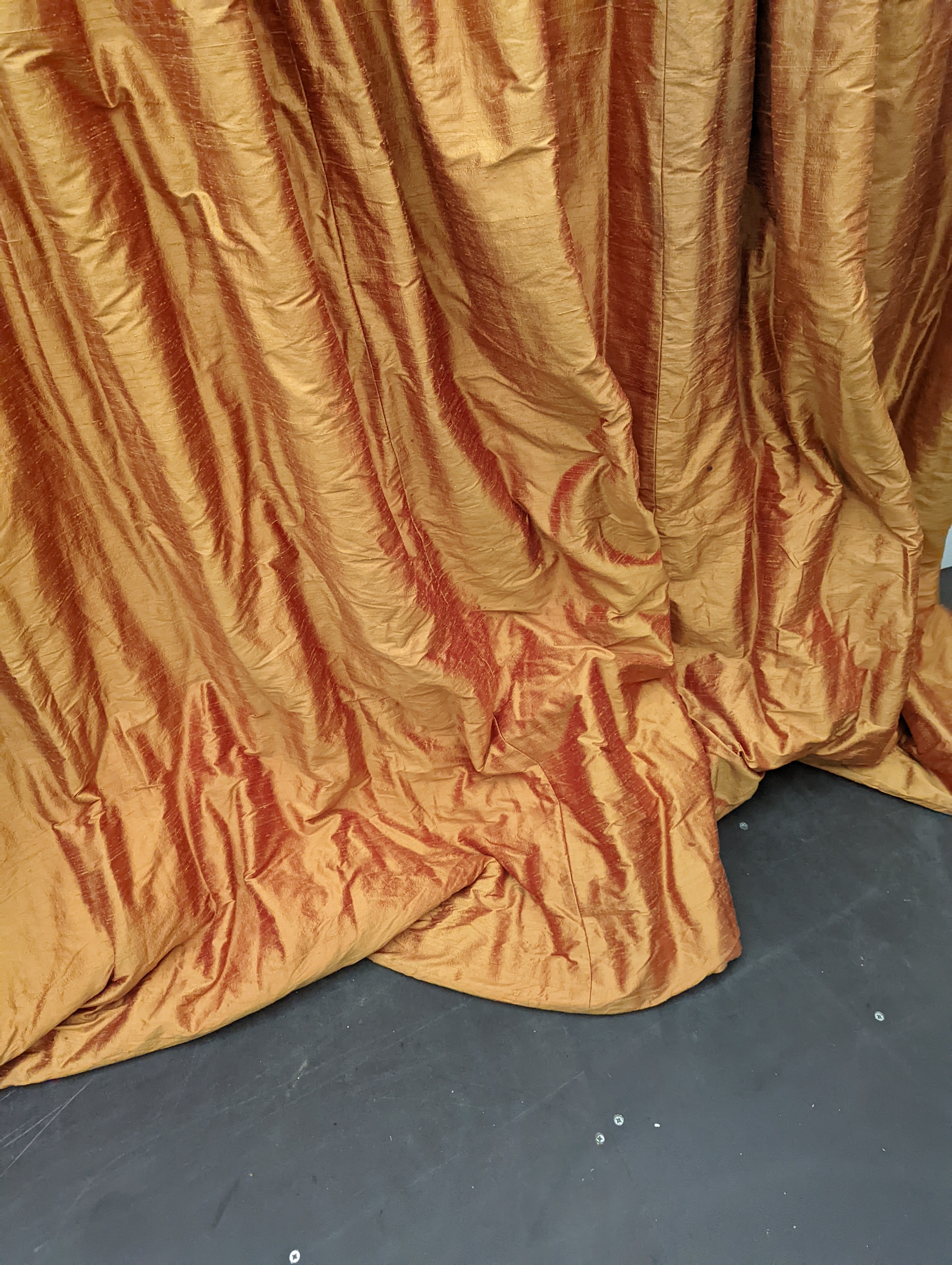 A pair of orange lined curtains. Approximate measurements: Width of top 180cm, Width of bottom 320cm Length 250cm